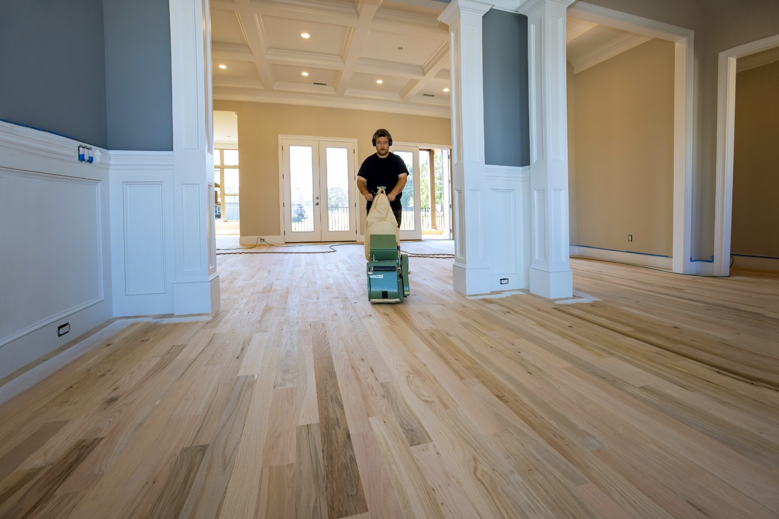 Professional wood floor sanding and restoration using a sanding machine on a natural timber floor.